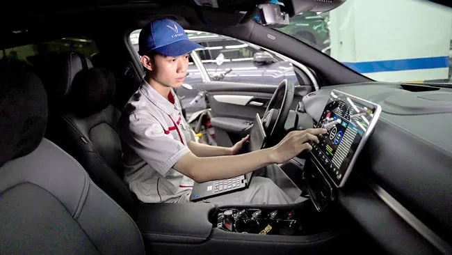 Kỹ thuật viên của VinFast nâng cấp phần mềm cho xe của khách hàng.