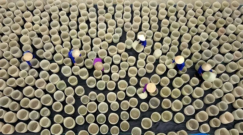 Công nhân Công ty Trách nhiệm Hữu Hạn Xuất khẩu và Đầu tư Thành Hóa làm các mặt hàng thủ công truyền thống. (Ảnh: Minh Đức/TTXVN)