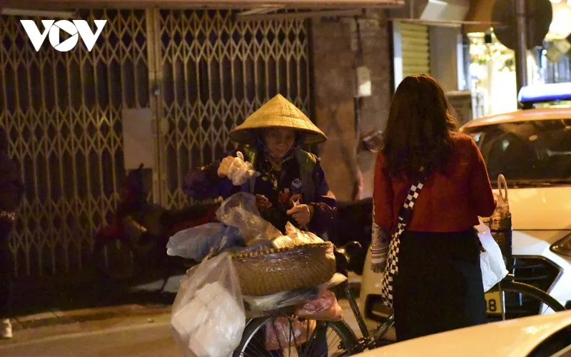 Trên phố Tạ Hiện, một người phụ nữ bán hàng rong vẫn đon đả mời khách.