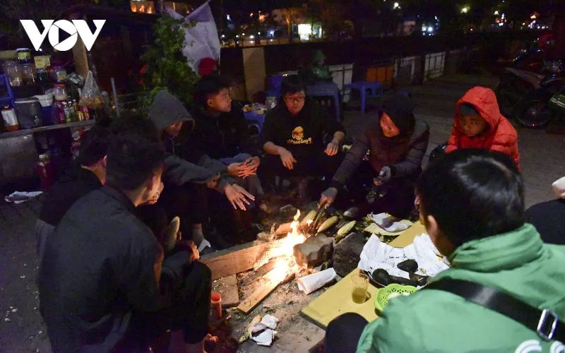 Những người xa lạ ngồi quây quần bên bếp lửa để hưởng chút ấm áp của mùa đông.