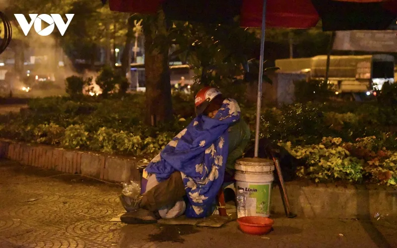 Người đàn ông làm nghề bơm vá xe ở phố Trần Nhật Duật (quận Hoàn Kiếm) ngủ vùi trong chiếc chăn mỏng vì ế khách.