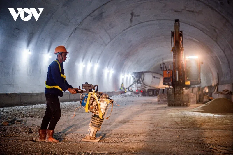 Các nhân công đang hàn cắt thi công mặt đường bê tông trong hầm Núi Vung.