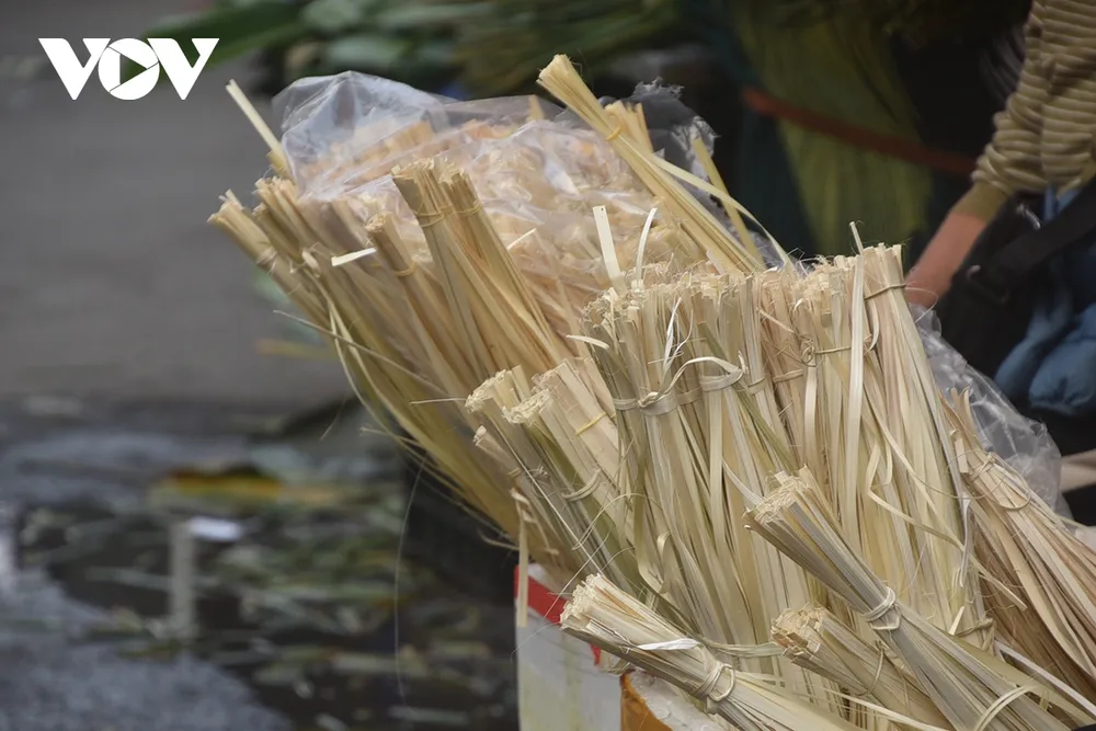Các sạp hàng bày bán từng bó lá dong xanh mướt, lạt giang buộc bánh được chẻ mỏng. Người mua, người bán rộn ràng, từ những gia đình truyền thống cho đến các tiểu thương đến lấy hàng về bán lại.