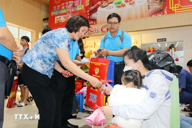 Lãnh đạo Thành phố Hồ Chí Minh tặng quà Tết và lì xì cho con công nhân các khu chế xuất, khu công nghiệp Thành phố Hồ Chí Minh về quê đón Tết. (Ảnh: Thanh Vũ/TTXVN)