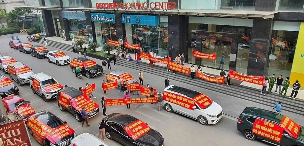 Cư dân Chung cư 302 đường Cầu Giấy (phường Dịch Vọng, quận Cầu Giấy, Hà Nội) tập trung trước sảnh tòa nhà, căng băng rôn đòi quyền lợi. (Ảnh: Thu Hằng/TTXVN)