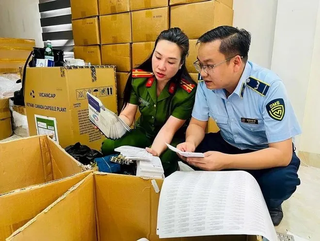 Lực lượng chức năng khám xét các địa điểm liên quan đến ổ nhóm sản xuất, buôn bán hàng giả là lương thực, thực phẩm, trang thiết bị y tế. Ảnh: Công an Hà Nội