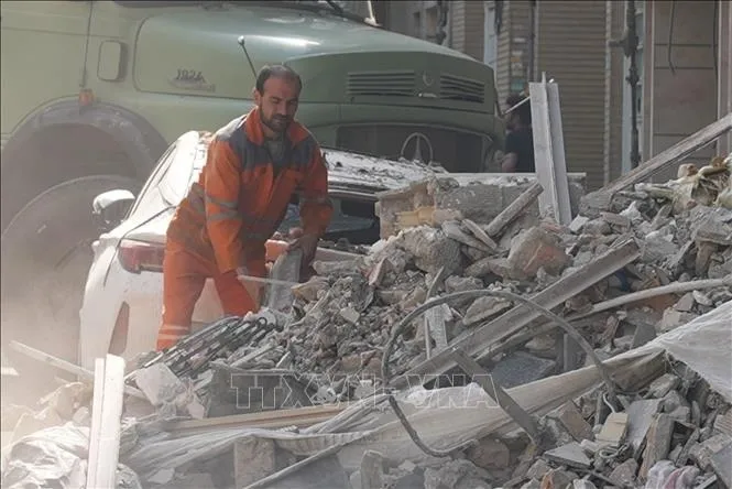 Lực lượng cứu hộ tại hiện trường toà nhà bị phá huỷ sau các vụ không kích của Israel xuống thủ đô Tehran, Iran ngày 13/6/2025. Ảnh: THX/TTXVN 