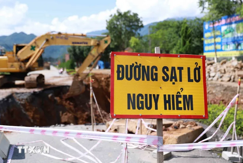 Các đơn vị chức năng cắm cảnh báo nguy hiểm do tình trạng sụt lún tại Km27+120 - Km27+200 trên quốc lộ 4D ở Lai Châu. (Ảnh: Quý Trung/TTXVN)