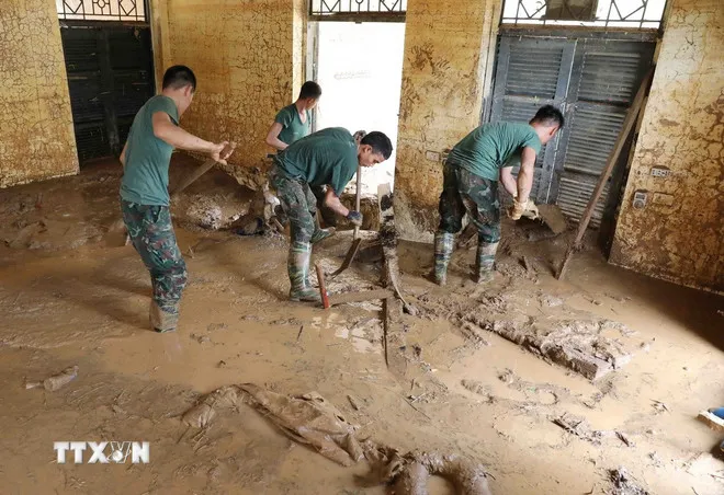 Lực lượng quân đội thu dọn bùn đất tại điểm trường mầm non Suối Lư, Điện Biên. (Ảnh: Trung Kiên/TTXVN)