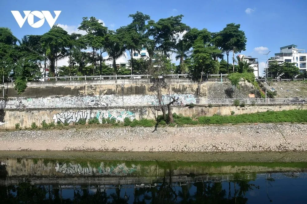 Mặt nước phẳng lặng không còn đen kịt, có thể soi thấy bóng các vật ven bờ.