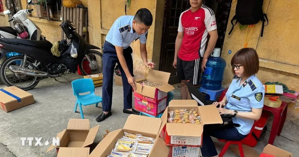 Lực lượng chức năng thu giữ bánh trung thu không rõ nguồn gốc xuất xứ. (Ảnh: TTXVN phát) 