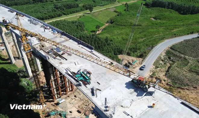 Nhà thầu thi công một cầu vượt qua thung lũng trên tuyến cao tốc Bắc-Nam phía Đông. (Ảnh: Khánh Hùng/Vietnam+)