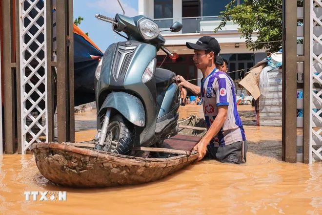 Người dân thôn Ngô Đạo, xã Đa Phúc (Hà Nội) di chuyển tài sản khỏi vùng bị ngập. (Ảnh: Hoàng Hiếu/TTXVN)