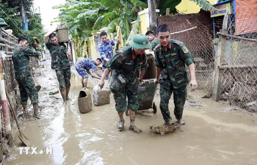 Tuyến Quốc lộ 40B bị sạt lở nặng, tuyến đường nối từ vùng đồng bằng về nhiều khu vực miền núi bị đình trệ hoàn toàn, hàng hóa tiếp tục được vận chuyển bằng sức người. (Ảnh: Đoàn Hữu Trung/TTXVN)