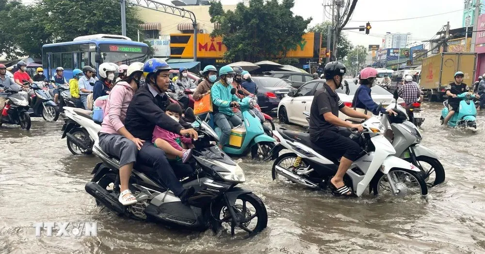 Nước dâng sớm, rút chậm trên đường Phạm Hữu Lầu, kéo dài từ cầu Phước Long đến đường Huỳnh Tấn Phát (Thành phố Hồ Chí Minh) khiến các phương tiện di chuyển chậm, khó khăn. (Ảnh: Hương Giang/TTXVN)