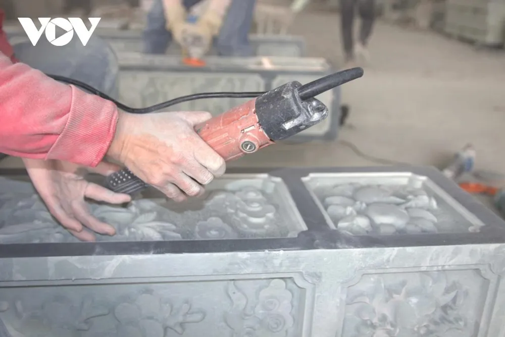 Trong xưởng đá phủ đầy bụi trắng, từng đường nét chạm khắc được thực hiện khẩn trương nhưng chính xác đến từng li. Người thợ chăm chú dõi theo mũi đục, điều chỉnh lực tay vừa đủ, để hoa văn mềm mại mà không làm sứt mẻ cấu trúc đá, giữ trọn hồn cốt của sản phẩm thủ công truyền thống.