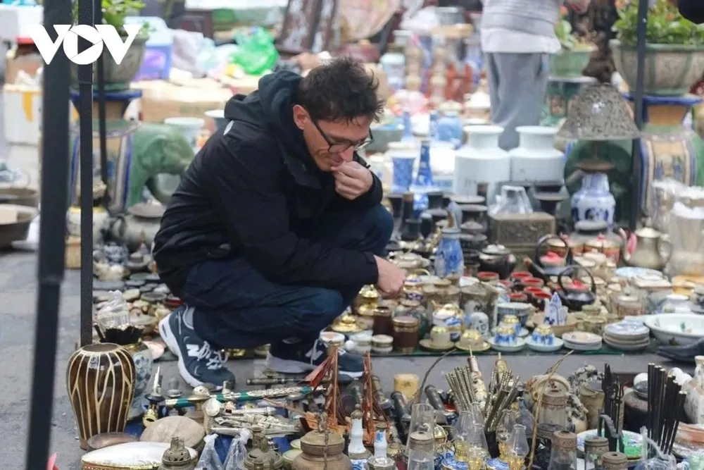 Du khách nước ngoài cũng thích thú ngắm đồ giả cổ tại phiên chợ.
