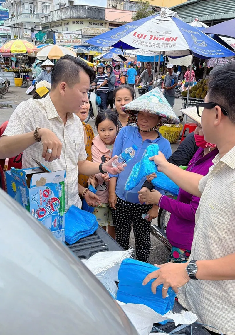 Các thành viên của Công ty XSKT Hậu Giang tặng quà cho người khó khăn ở Vĩnh Long.jpg