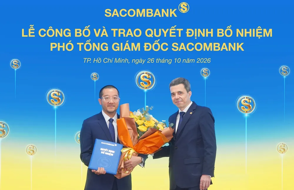 Ông Nguyễn Xuân Ái Quốc nhận quyết định bổ nhiệm và hoa chúc mừng từ ông Loic Faussier - Tổng giám đốc Sacombank