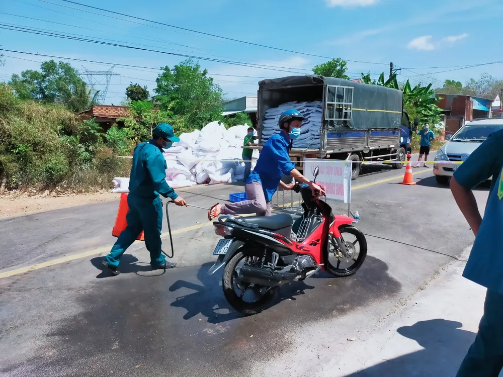 Lực lượng chức năng xã An Bình, huyện Phú Giáo phun thuốc khử khuẩn phương tiện ở ấp Cà Na. Ảnh chụp tháng 2-2021