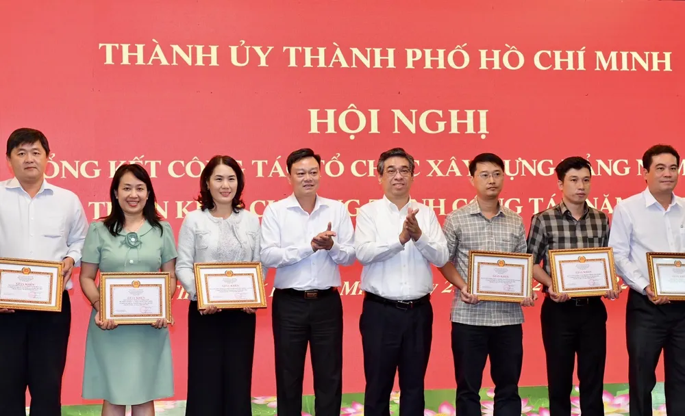 Trưởng Ban Tổ chức Thành ủy TPHCM Nguyễn Phước Lộc trao giấy khen của Ban Tổ chức Thành ủy TPHCM cho các tập thể. Ảnh: VIỆT DŨNG