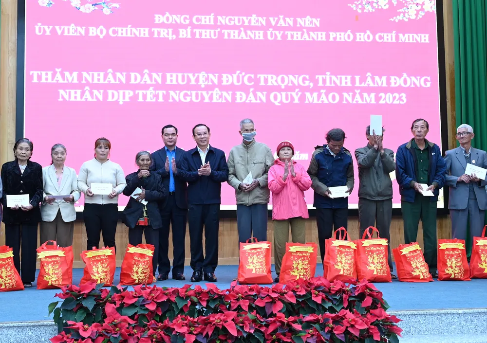 Bí thư Thành ủy TPHCM Nguyễn Văn Nên và Chủ tịch Tổng Liên Đoàn Lao động Việt Nam Nguyễn Đình Khang trao quà cho bà con tỉnh Lâm Đồng. Ảnh: VĂN MINH