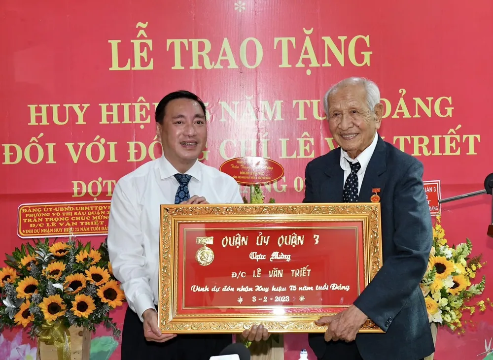Bí thư Quận ủy quận 3 Phạm Thành Kiên chúc mừng đồng chí Lê Văn Triết nhận Huy hiệu 75 năm tuổi Đảng. Ảnh: VIỆT DŨNG Bí thư Quận ủy quận 3 Phạm Thành Kiên chúc mừng đồng chí Lê Văn Triết nhận Huy hiệu 75 năm tuổi Đảng. Ảnh: VIỆT DŨNG