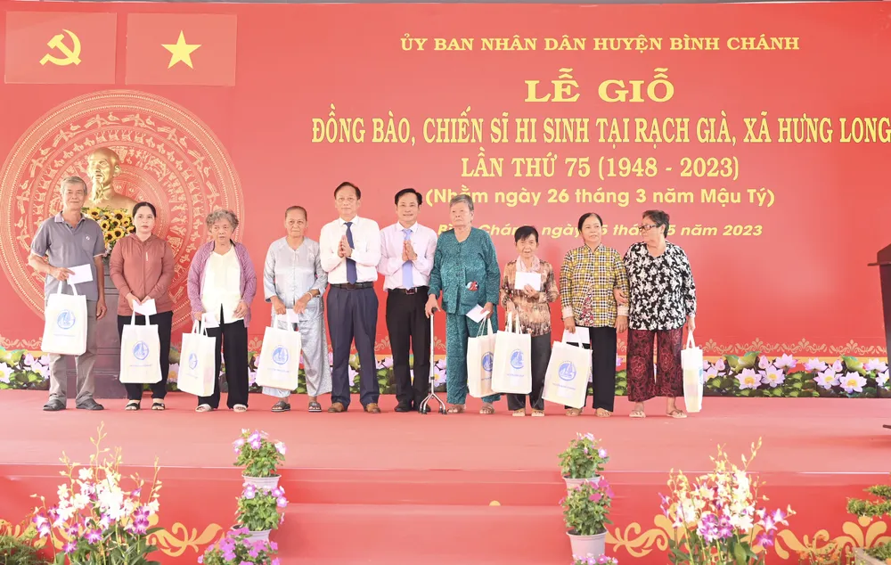 Bí thư Huyện ủy huyện Bình Chánh Trần Văn Nam và Phó Bí thư Thường trực Huyện ủy, Chủ tịch HĐND huyện Bình Chánh Trần Văn Lũy trao quà cho gia đình chính sách khó khăn. Ảnh: VĂN MINH