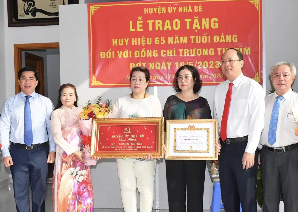 Đại diện gia đình đồng chí Trương Thị Tím nhận quyết định tặng Huy hiệu 65 năm tuổi Đảng. Ảnh: VIỆT DŨNG