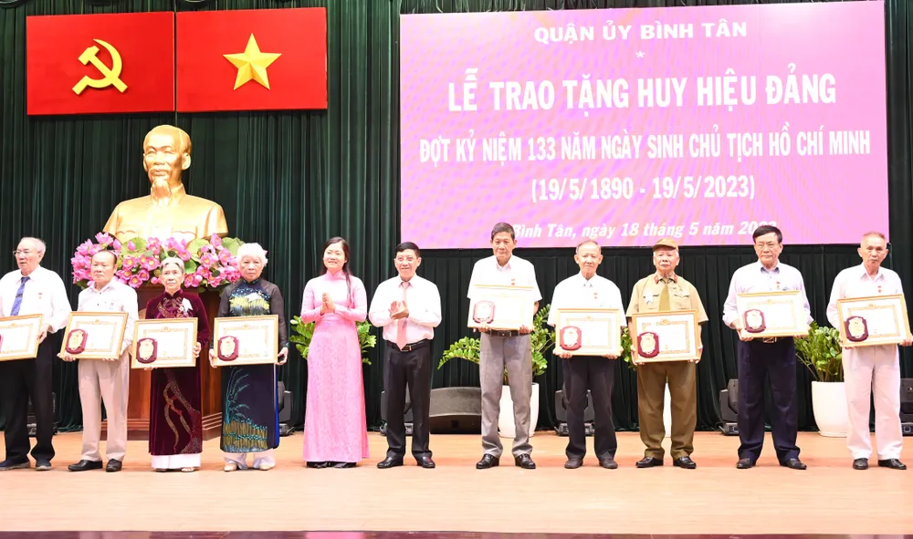 Trưởng Ban Tổ chức Quận ủy Nguyễn Văn Hạnh và Phó Chủ tịch UBND quận Bình Tân Lê Thị Ngọc Dung trao Huy hiệu Đảng. Ảnh: VĂN MINH