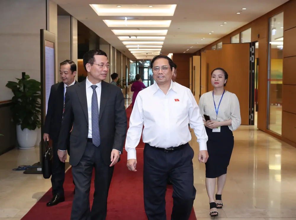 Thủ tướng Phạm Minh Chính trao đổi với Bộ trưởng Bộ TT-TT Nguyễn Mạnh Hùng bên hành lang Quốc hội, ngày 22-6-2023. Ảnh: QUANG PHÚC