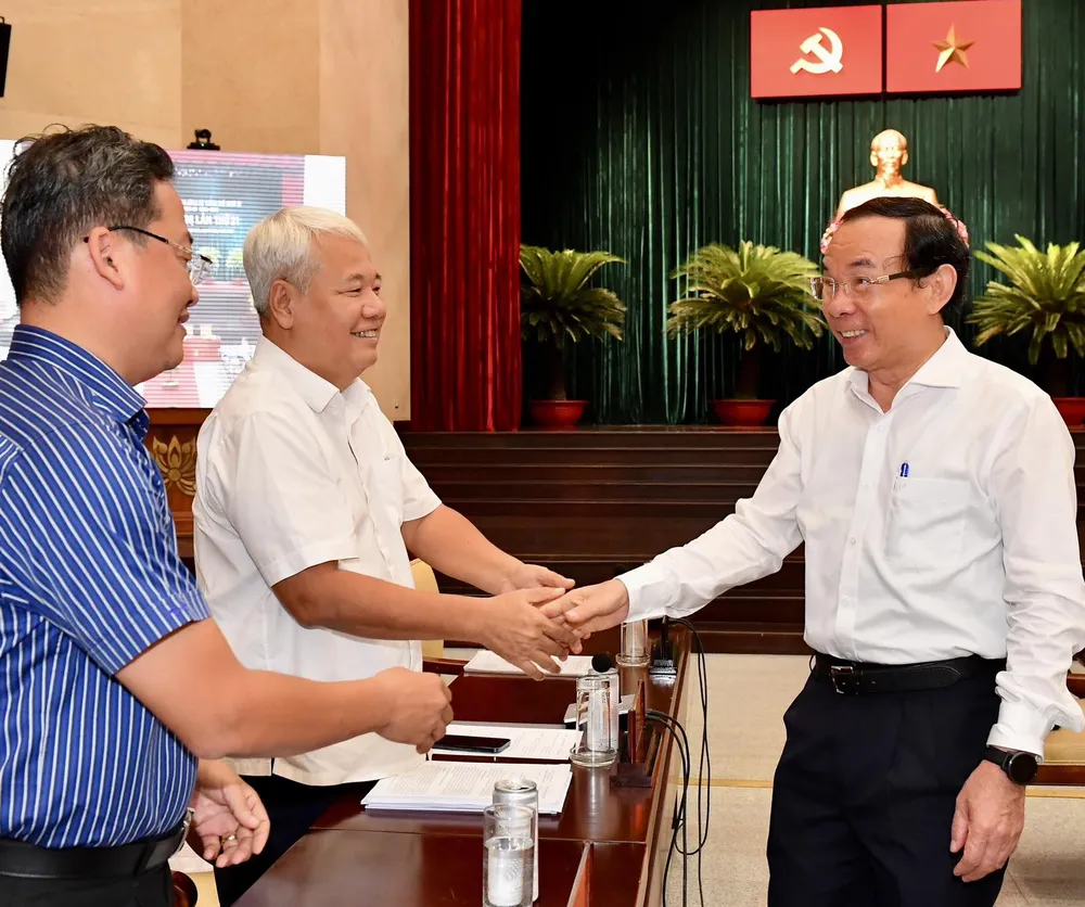 Bí thư Thành ủy TPHCM trao đổi với các đại biểu trước phiên họp. Ảnh: VIỆT DŨNG