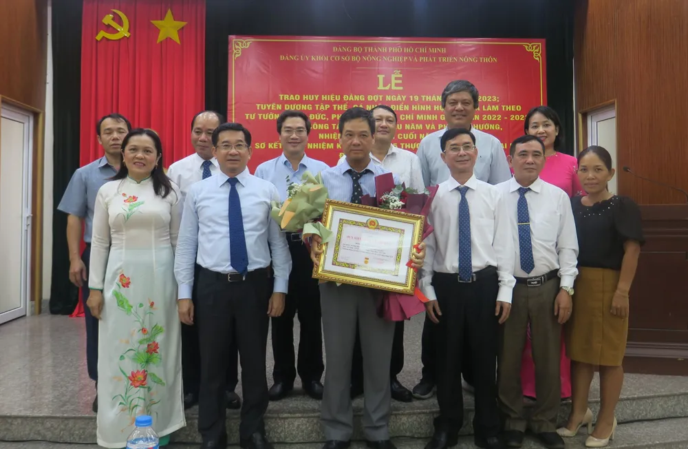 Chủ nhiệm Ủy ban Kiểm tra Thành ủy TPHCM Dương Ngọc Hải trao Huy hiệu 30 năm tuổi Đảng cho đồng chí Lê Quang Đức. Ảnh: EGM