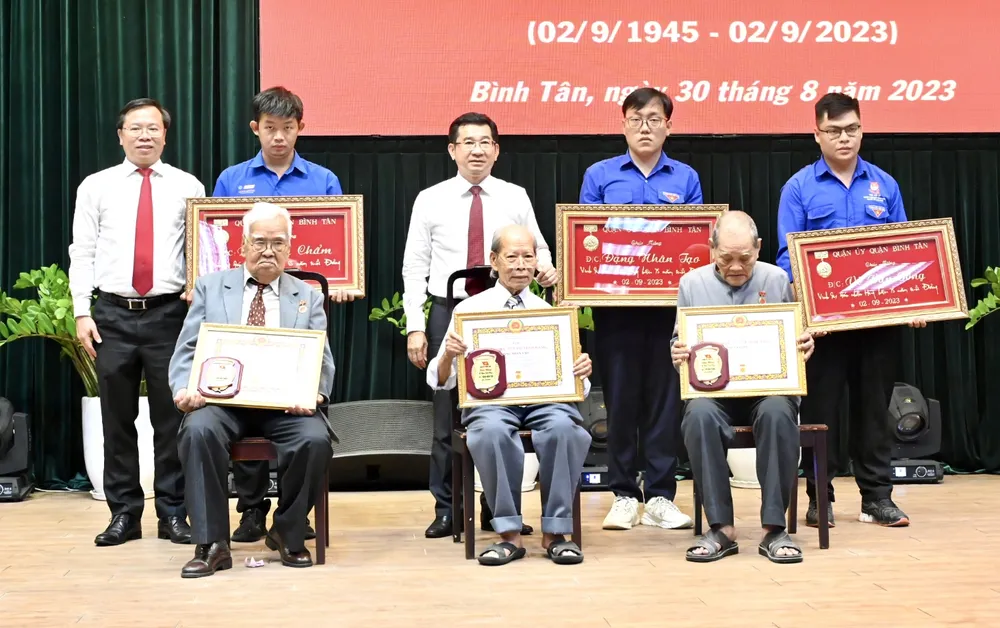 Chủ nhiệm Ủy ban Kiểm tra Thành ủy TPHCM Dương Ngọc Hải và Bí thư Quận ủy quận Bình Tân Huỳnh Khắc Điệp trao Huy hiệu Đảng cho các đồng chí lão thành cách mạng. Ảnh: VĂN MINH