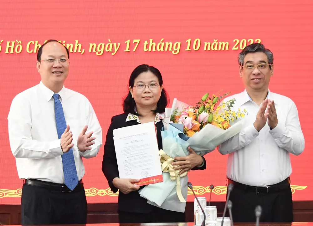 Phó Bí thư Thành ủy TPHCM Nguyễn Hồ Hải và Phó Bí thư Thành ủy, Trưởng Ban Tổ chức Thành ủy TPHCM Nguyễn Phước Lộc trao quyết định, tặng hoa đồng chí Lê Thị Thanh Thúy. Ảnh: VIỆT DŨNG