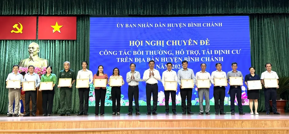 Bí thư Huyện ủy huyện Bình Chánh Trần Văn Nam và Chủ tịch UBND huyện Bình Chánh Võ Đức Thanh tặng giấy khen cho các tập thể, cá nhân tại hội nghị