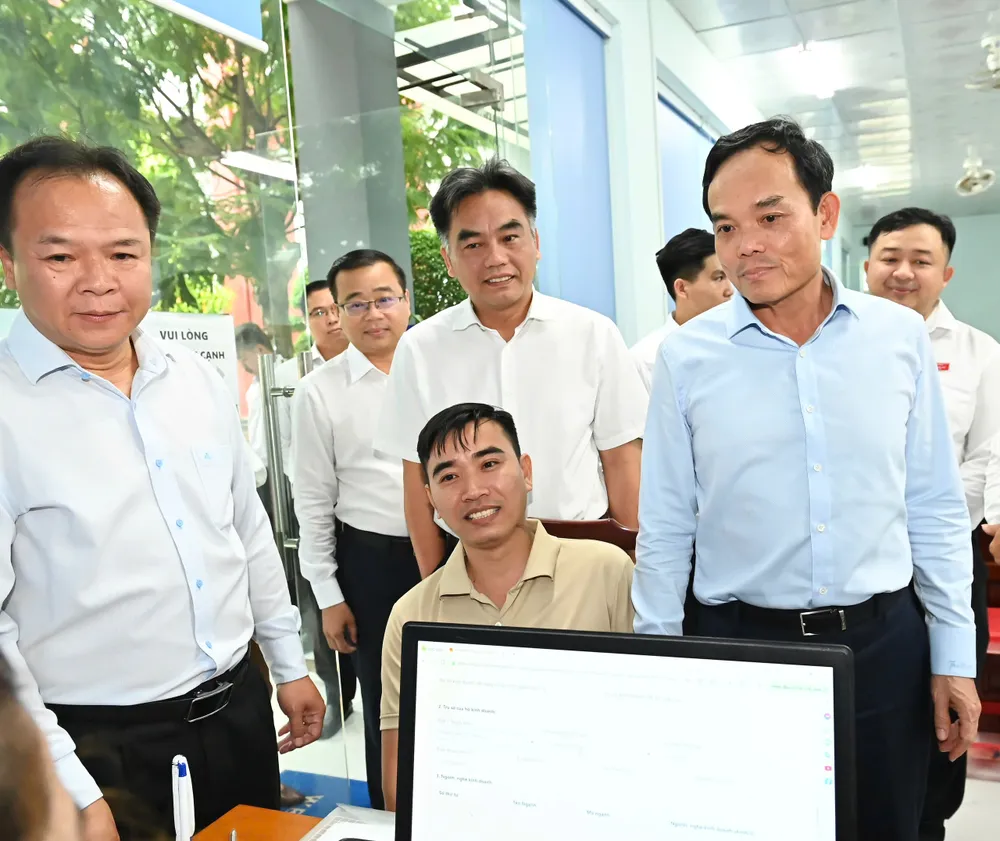 Bí thư Thành ủy TPHCM Trần Lưu Quang thăm hỏi người dân đến làm thủ tục hành chính. Ảnh: VIỆT DŨNG