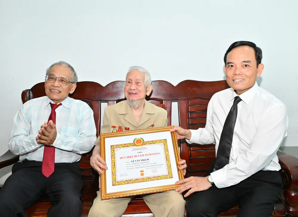 Bí thư Thành ủy TPHCM Trần Lưu Quang trao tặng Huy hiệu 80 năm tuổi Đảng đến đồng chí Lê Văn Thạch. Ảnh: VIỆT DŨNG