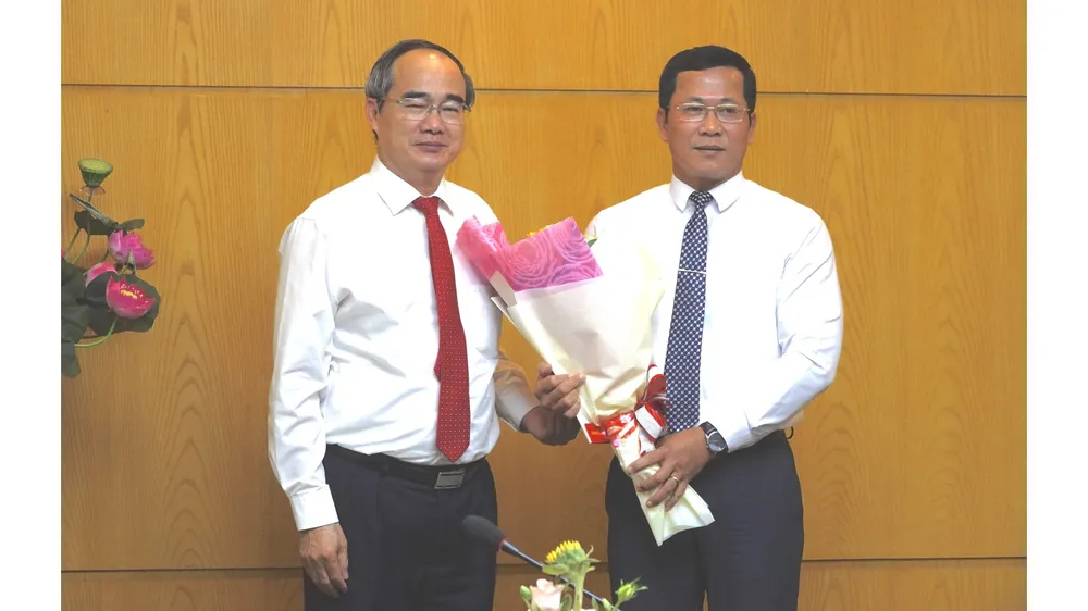 Bí thư Thành ủy TPHCM Nguyễn Thiện Nhân trao quyết định điều động chỉ định Bí thư Quận ủy quận 4 giữ chức Bí thư Quận ủy quận 12. Ảnh: KIỀU PHONG  