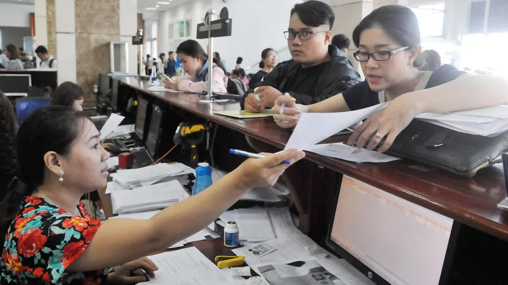 Đại diện doanh nghiệp trao đổi với nhân viên Cục thuế TPHCM. Ảnh: CAO  THĂNG