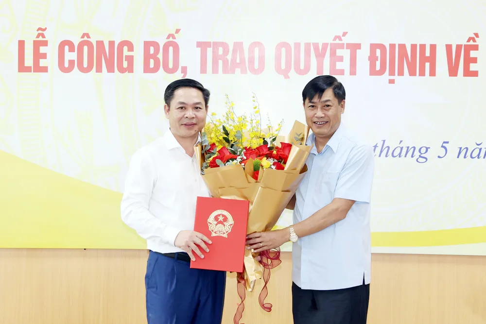 Chủ nhiệm Ủy ban Công tác đại biểu Nguyễn Hữu Đông trao quyết định và tặng hoa chúc mừng Vụ trưởng Vụ Công tác đại biểu Chử Văn Thìn. Ảnh: CẨM HÀ 