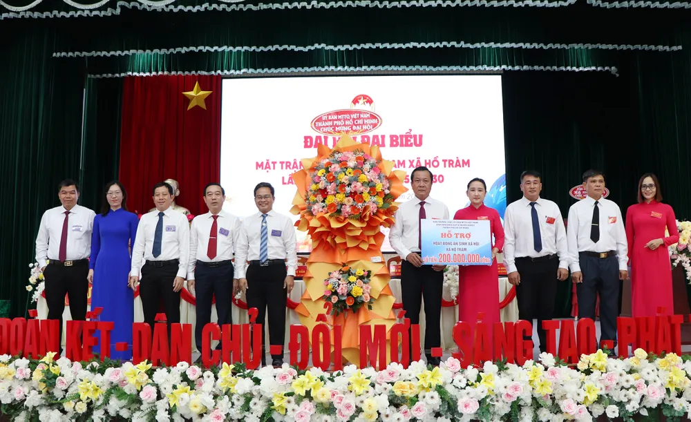 Đồng chí Phạm Minh Tuấn, Phó Chủ tịch Ủy ban MTTQ Việt Nam TPHCM tặng hoa và biểu trưng hỗ trợ 200 triệu đồng của Ban Thường trực Ủy ban MTTQ Việt Nam TPHCM cho xã Hồ Tràm thực hiện các hoạt động an sinh xã hội..jpg