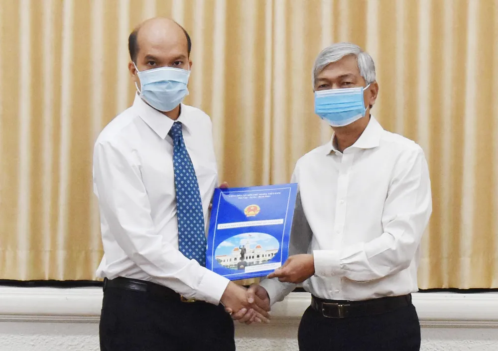 Phó Chủ tịch UBND TPHCM Võ Văn Hoan trao quyết định cho ông Nguyễn Nghĩa Hiệp. Ảnh: ĐÌNH LÝ
