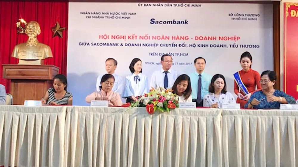 Các hộ tiểu thương tại TPHCM ký kết hợp đồng tín dụng vay vốn với Sacombank sáng ngày 30-11  