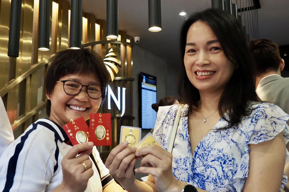 Khách hàng tại quận Bình Thạnh vui mừng khoe vàng vừa mua vàng tại cửa hàng PNJ trong ngày Vía Thần Tài. Ảnh: HOÀNG HÙNG