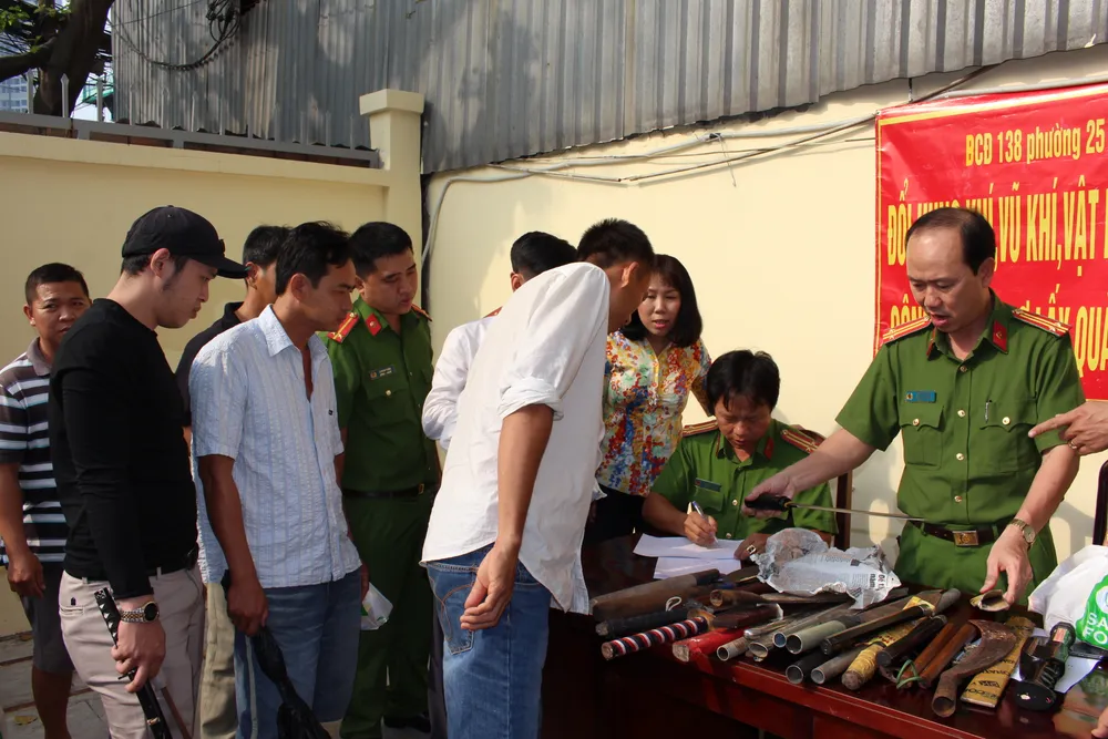 Nhiều người dân tới giao nộp hung khí để nhận quà. Ảnh: CHÍ THẠCH