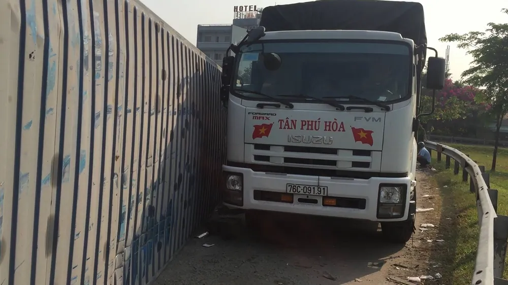 Xe container ôm cua lật nhào suýt đè xe tải ảnh 1