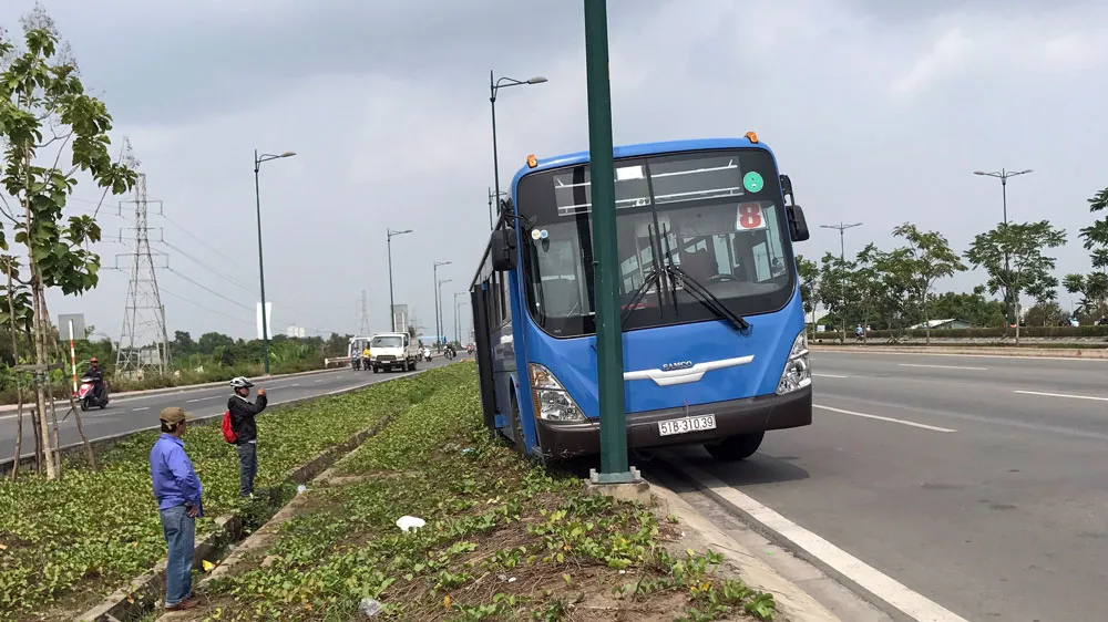 Xe buýt lao ra lề đường, kẹt vào rãnh thoát nước ảnh 1