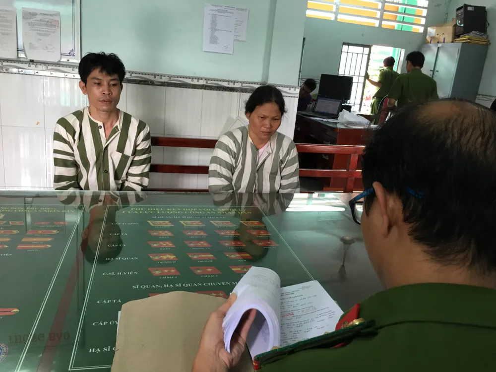 Công an lấy lời khai của cặp nam nữ dùng đá tấn công công an. Ảnh: CHÍ THẠCH