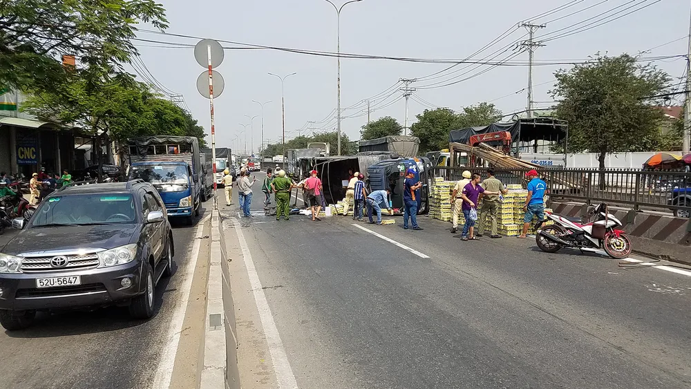  Xe tải lật giữa QL1, người dân cùng CSGT dọn hàng trăm thùng nước ngọt giúp tài xế ảnh 2